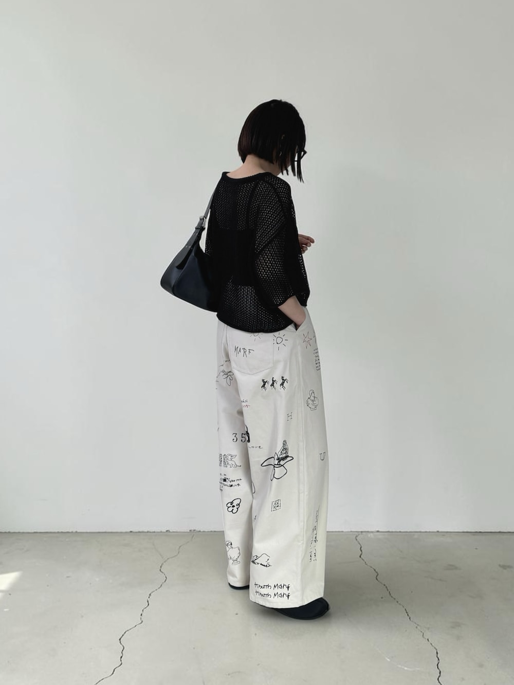 ブラック系のニット/セーター、ブラック系のハンドバッグ、ブラック系のサンダルを着用したレディースの春コーディネートの3枚目の写真
