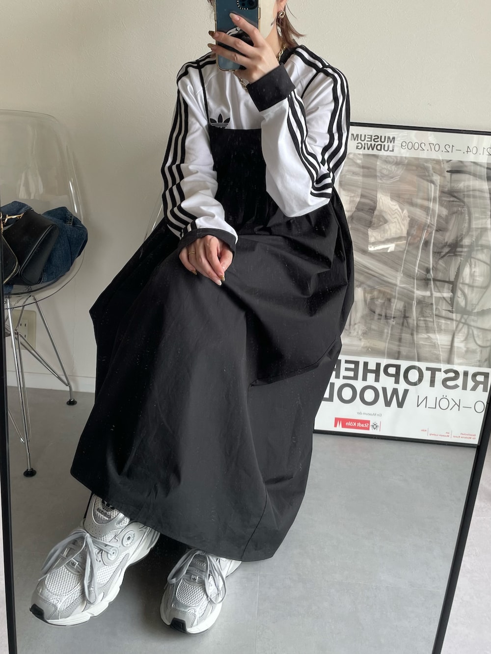 ブラック系のワンピース、ホワイト系のTシャツ/カットソー、グレー系のスニーカーを着用したレディースの春コーディネートの2枚目の写真