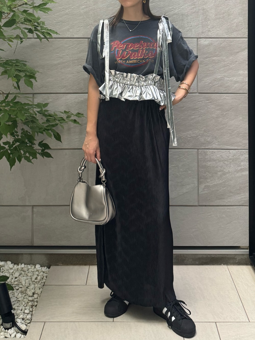 ブラック系のスカート、ブラック系のスニーカー、グレー系のTシャツ/カットソーを着用したレディースの夏コーディネートの4枚目の写真