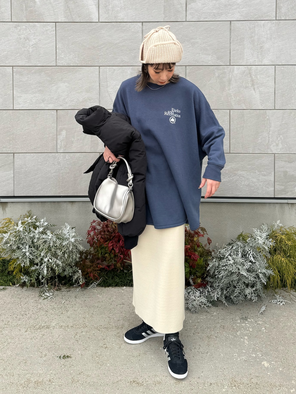 ブルー系のスウェット、シルバー系のショルダーバッグ、ブラック系のスニーカーを着用したレディースの冬コーディネートの4枚目の写真