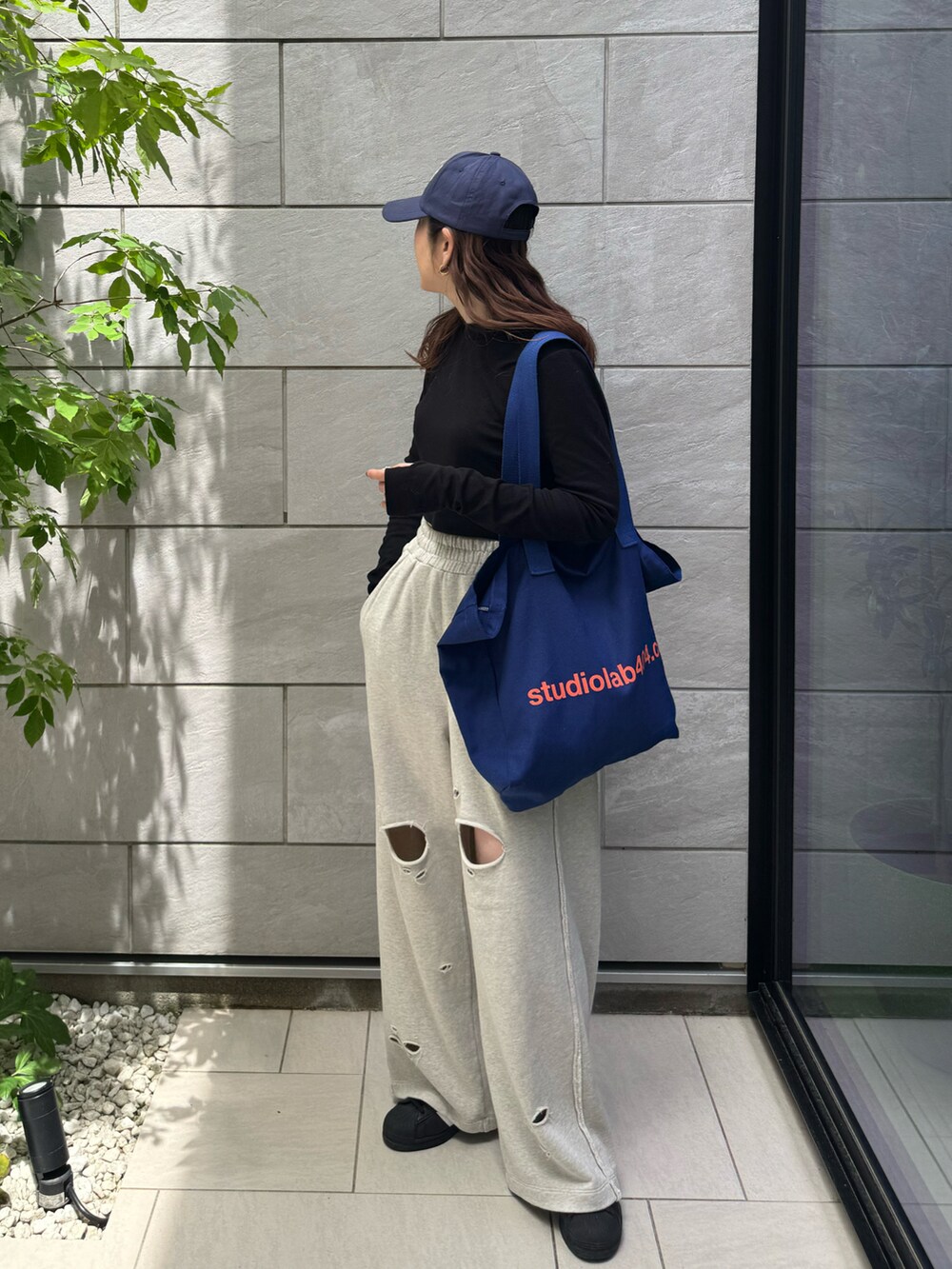 グレー系のスウェットパンツ、ブラック系のTシャツ/カットソー、ブラック系のスニーカーを着用したレディースの春コーディネートの5枚目の写真