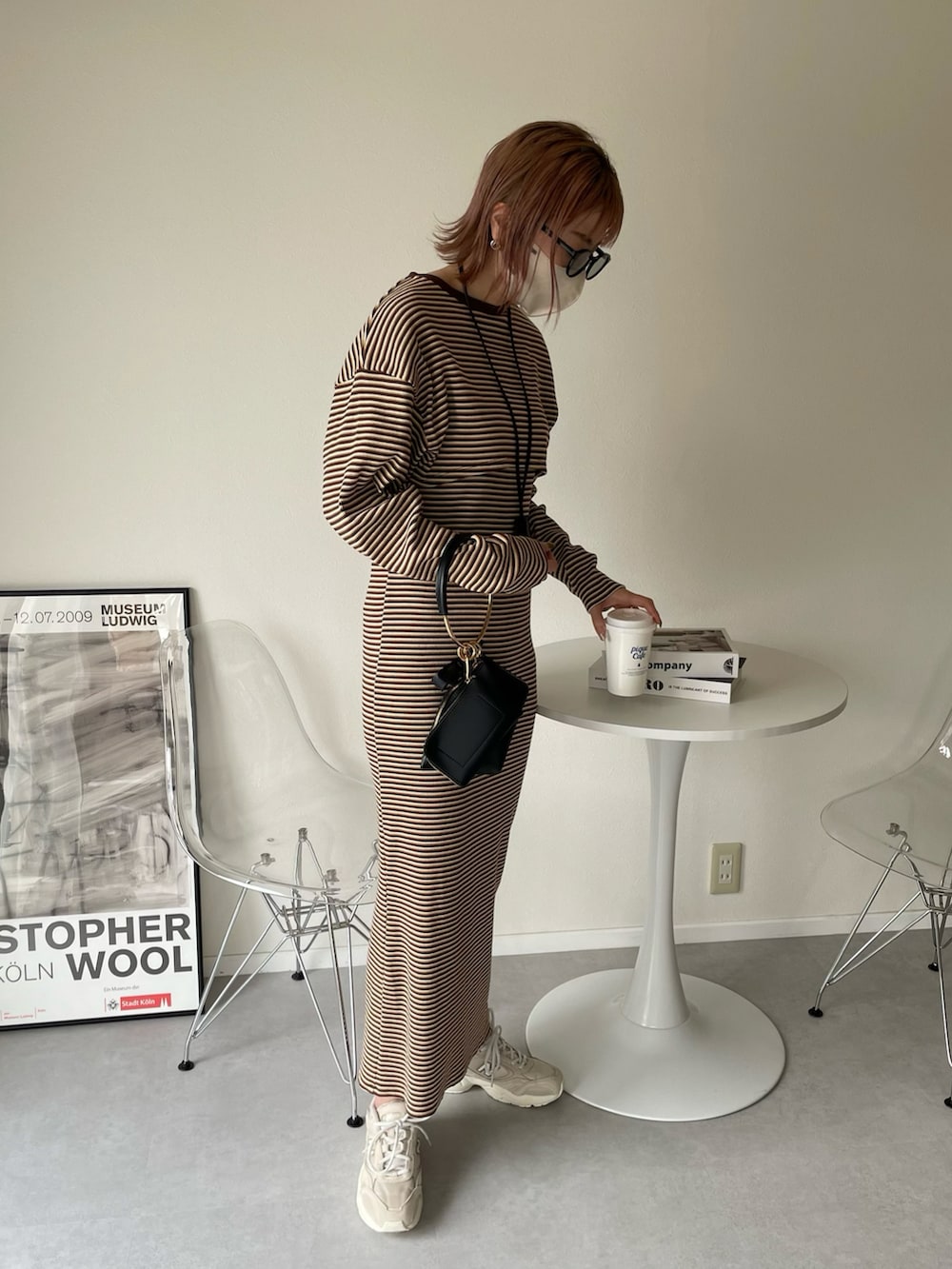 ブラウン系のワンピース、ブラック系のハンドバッグ、グリーン系のMA-1を着用したレディースの春コーディネートの4枚目の写真