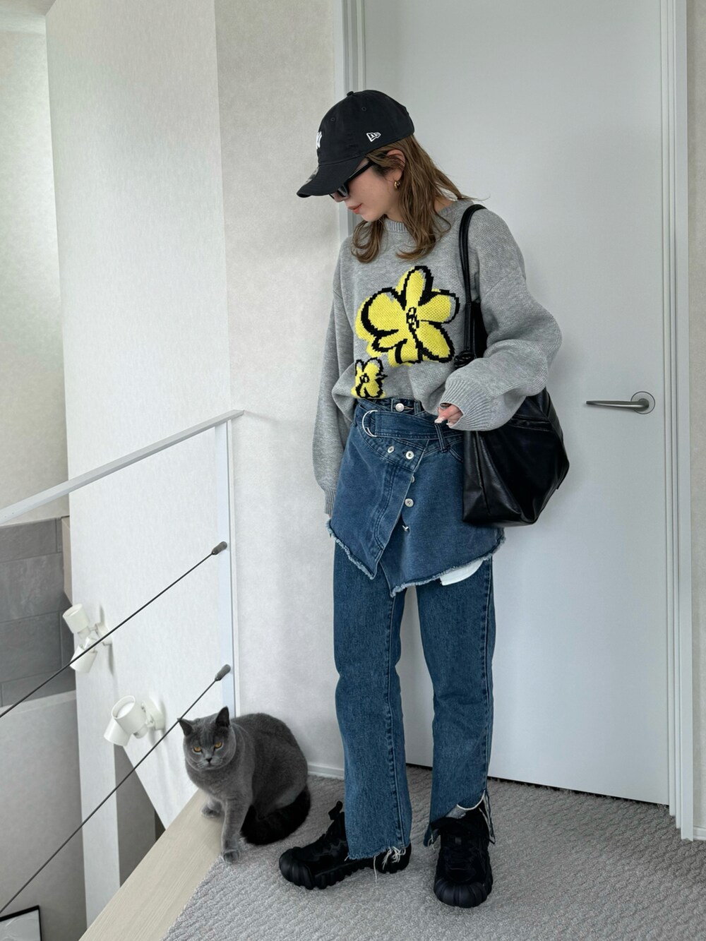 グレー系のニット/セーター、ブラック系のスニーカー、ブラック系のショルダーバッグを着用したレディースの秋コーディネートの4枚目の写真