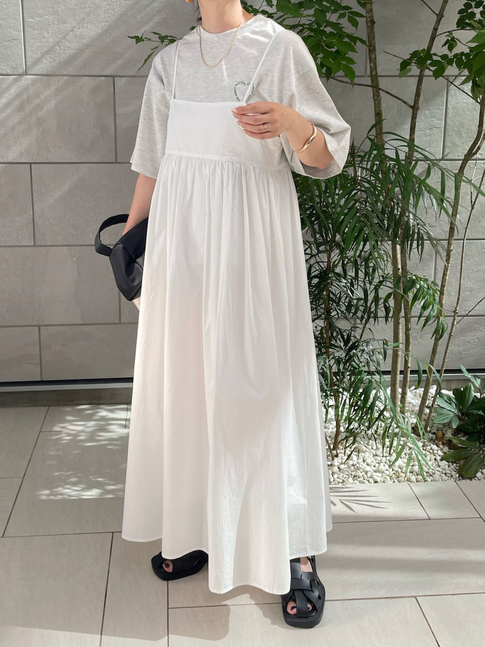 ホワイト系のワンピース、ブラック系のサンダルを着用したレディースの春コーディネートの2枚目の写真