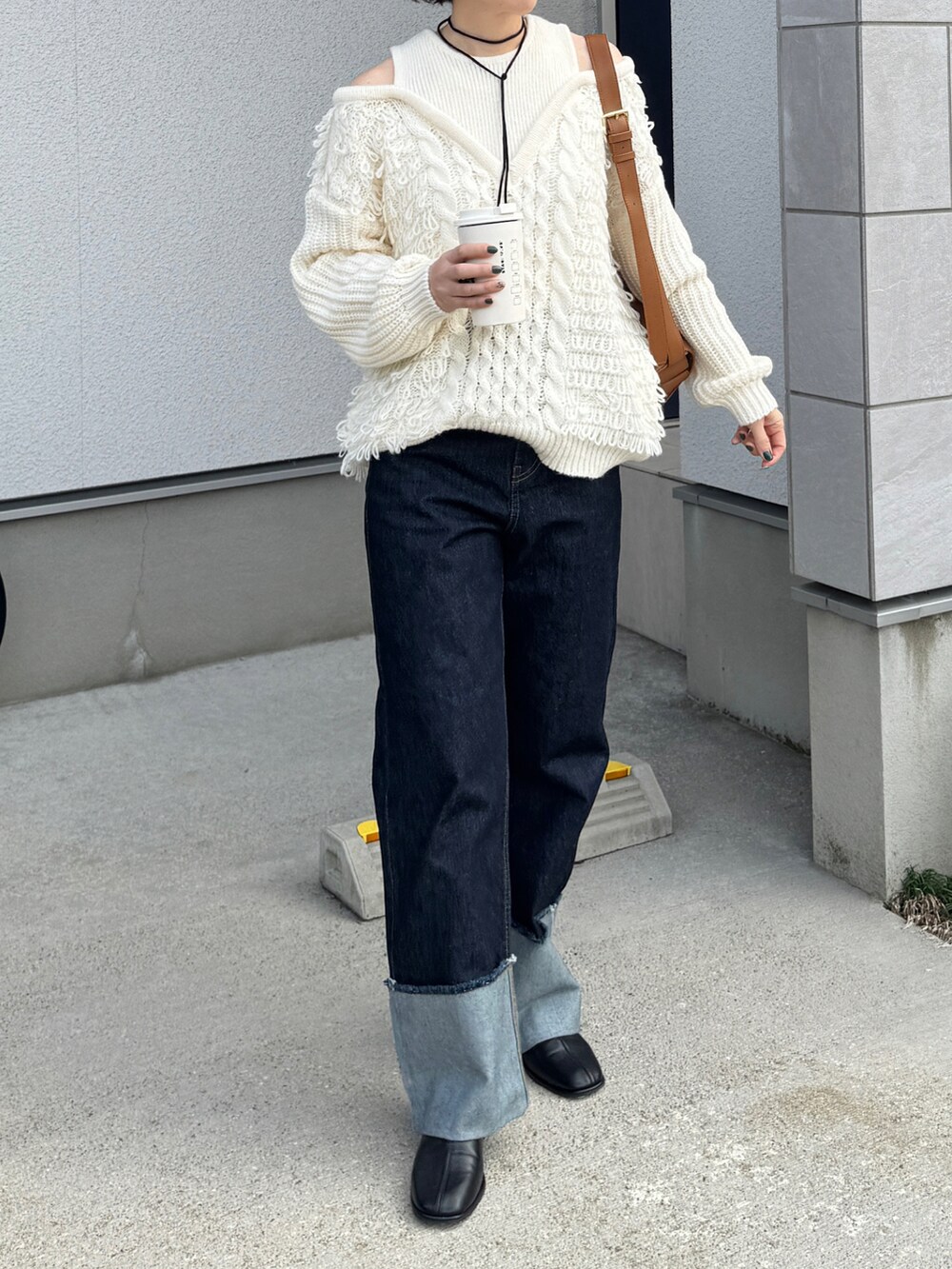 ブルー系のデニムパンツ、ベージュ系のショルダーバッグ、ホワイト系のニット/セーターを着用したレディースの秋コーディネートの2枚目の写真