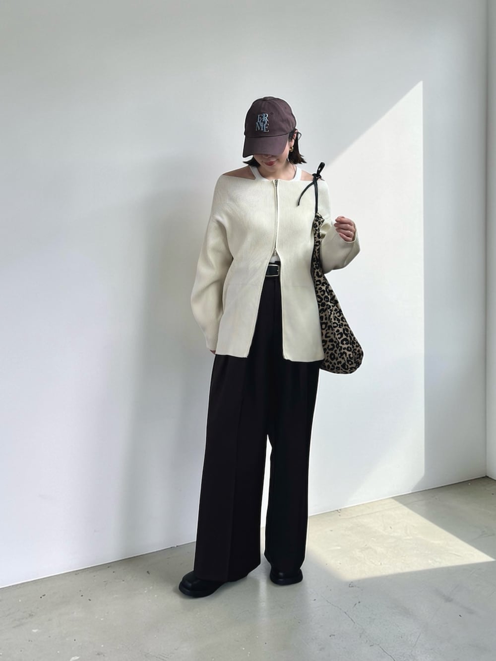 ホワイト系のカーディガン/ボレロ、ブラウン系のその他パンツ、ブラック系のその他シューズを着用したレディースの春コーディネートの2枚目の写真