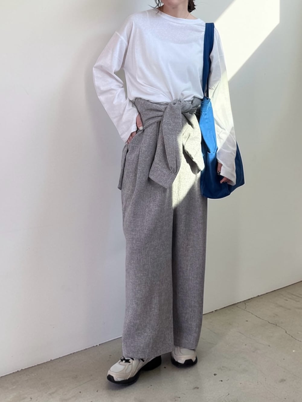 ホワイト系のTシャツ/カットソー、グレー系のシャツ/ブラウス、グレー系のスラックスを着用したレディースの春コーディネートの3枚目の写真