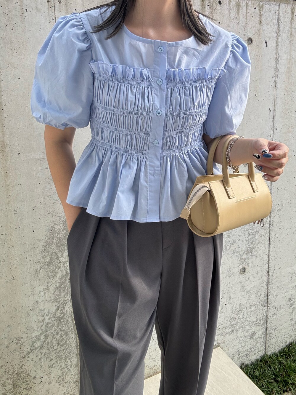 ブルー系のシャツ/ブラウス、グレー系のスラックス、ベージュ系のハンドバッグを着用したレディースの夏コーディネートの4枚目の写真