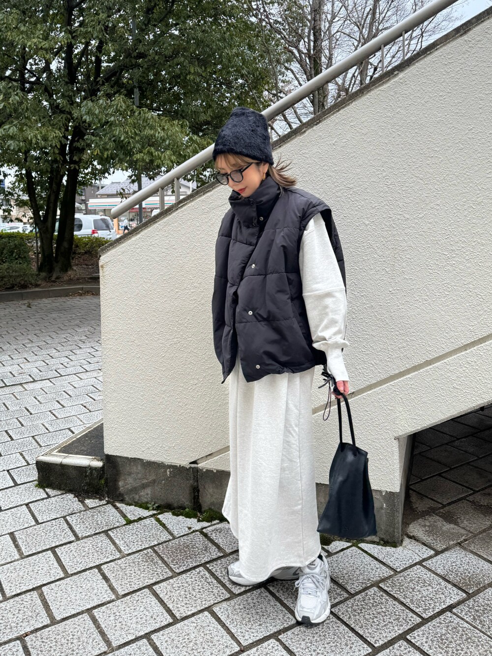 グレー系のスニーカー、ブルー系の折りたたみ傘を着用したレディースの冬コーディネートの3枚目の写真