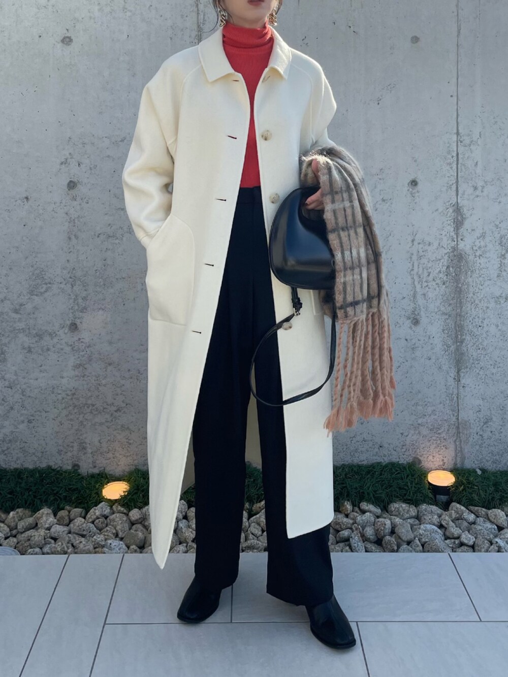 ホワイト系のステンカラーコート、ブラック系のその他パンツ、ブラック系のブーツを着用したレディースの秋コーディネートの3枚目の写真