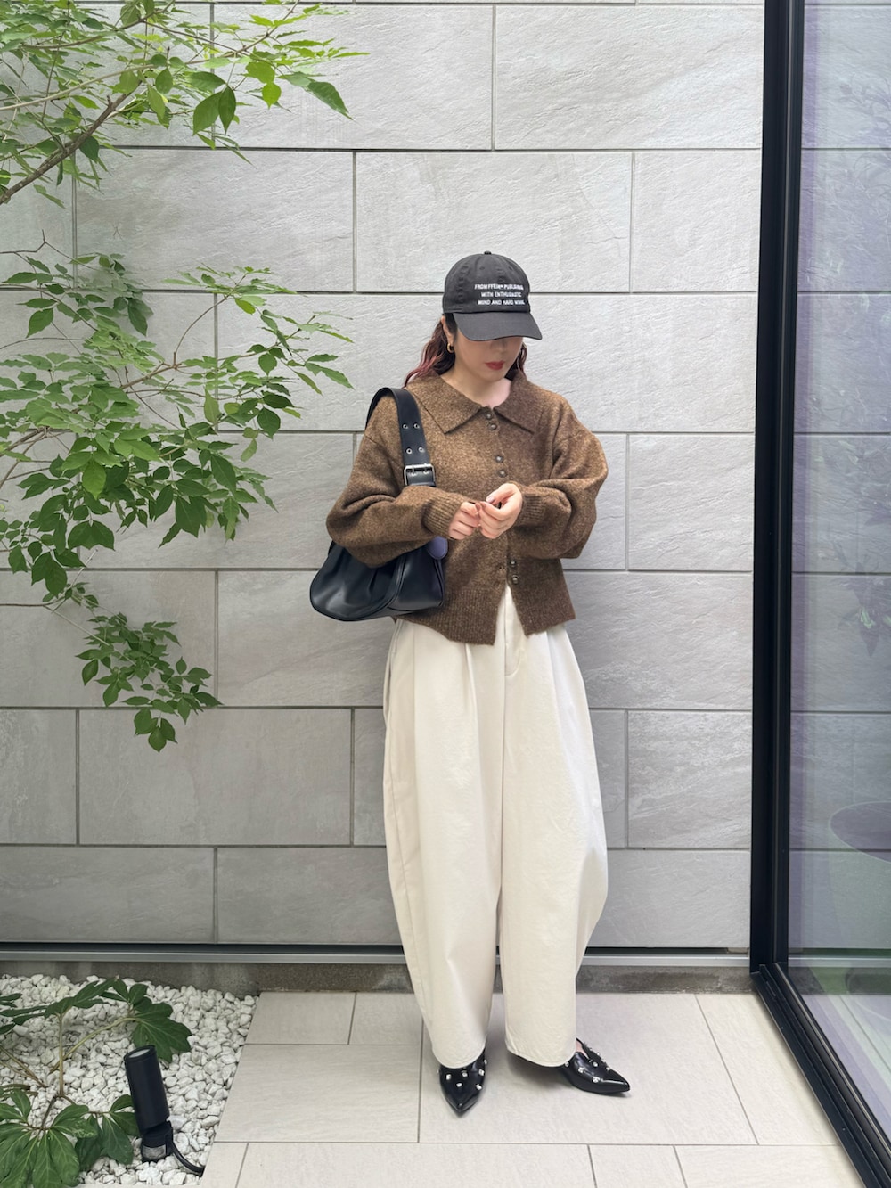 ホワイト系のチノパンツ、ブラック系のパンプス、ブラウン系のカーディガン/ボレロを着用したレディースの秋コーディネートの2枚目の写真