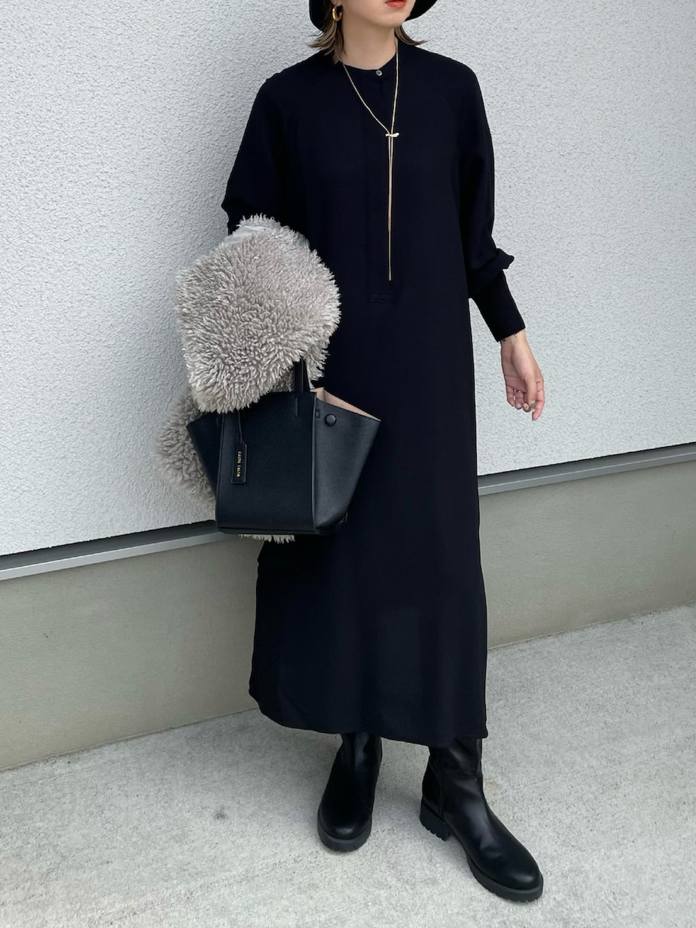 ブラック系のワンピース、ブラック系のハンドバッグ、ブラック系のブーツを着用したレディースの秋コーディネートの4枚目の写真