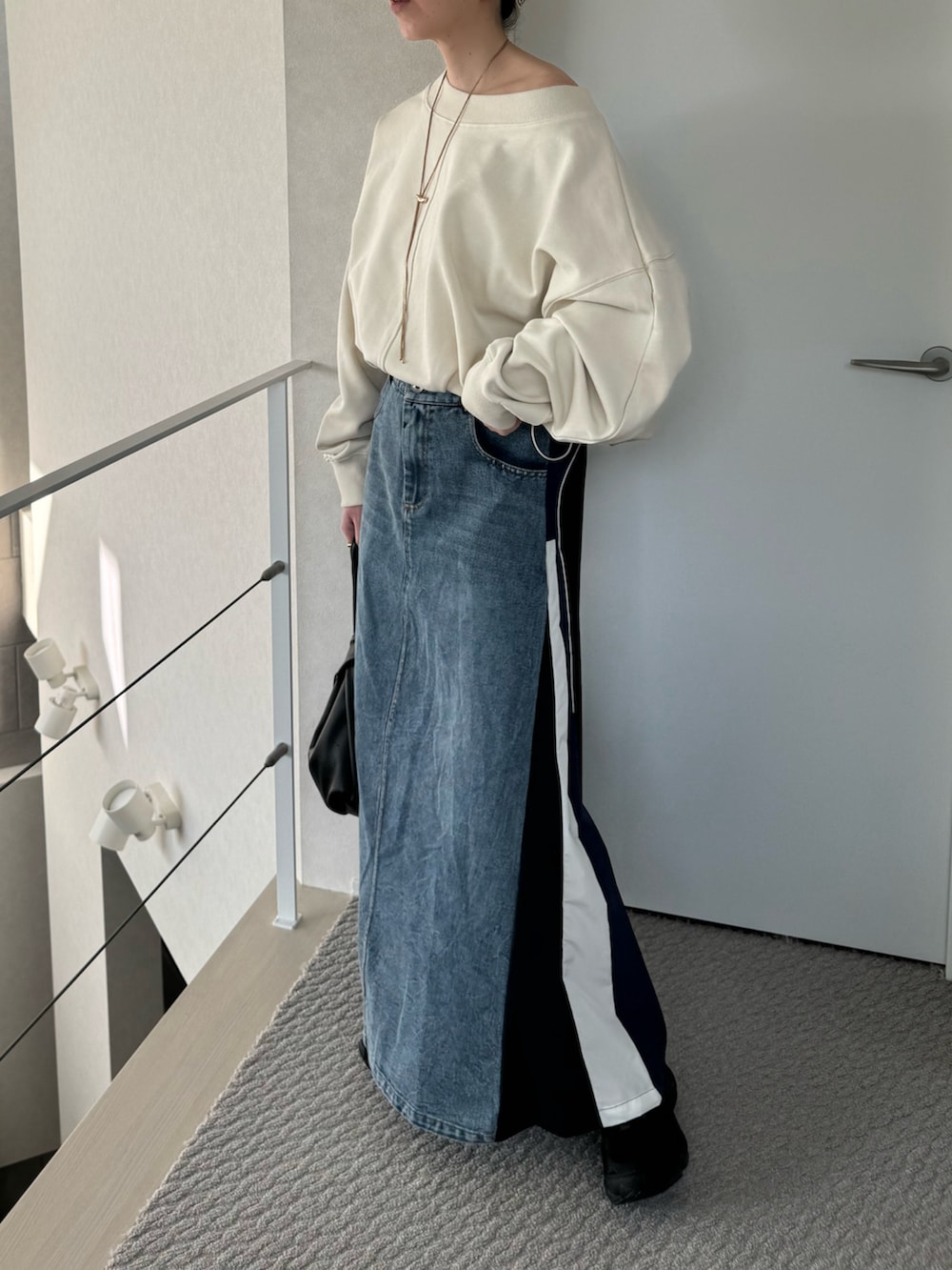 ホワイト系のスウェット、ブルー系のスカート、ブラック系のスニーカーを着用したレディースの春コーディネートの4枚目の写真