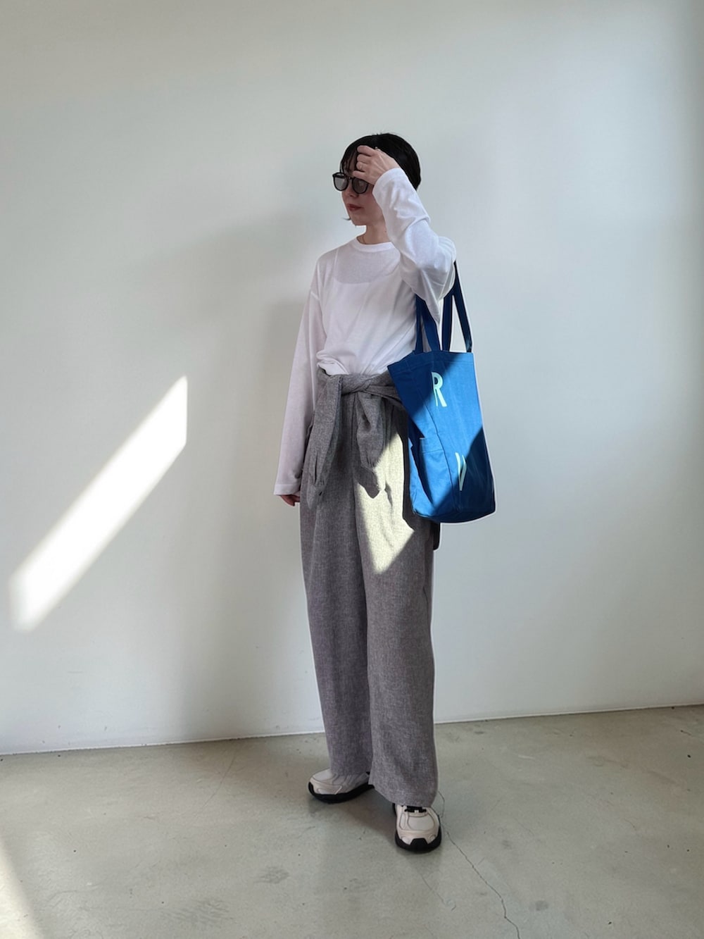 ホワイト系のTシャツ/カットソー、グレー系のシャツ/ブラウス、グレー系のスラックスを着用したレディースの春コーディネートの2枚目の写真