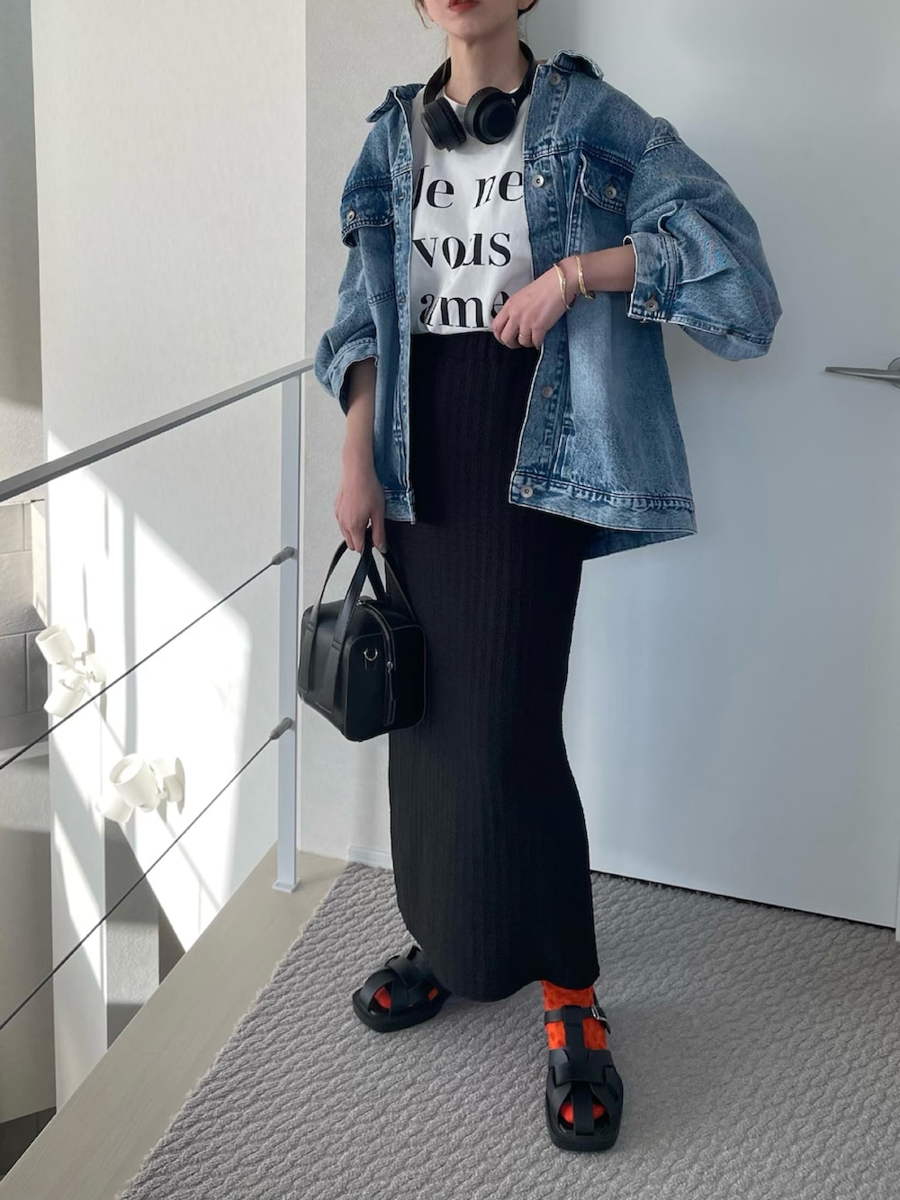 ホワイト系のTシャツ/カットソー、ブラック系のスカート、ブラック系のサンダルを着用したレディースの春コーディネートの2枚目の写真