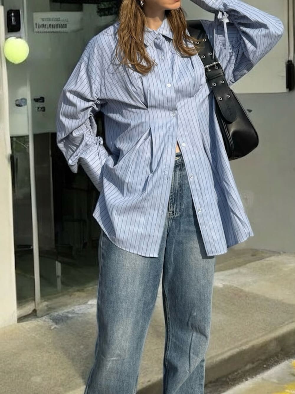 ブルー系のシャツ/ブラウス、イエロー系のスニーカー、ブルー系のデニムパンツを着用したレディースの春コーディネートの3枚目の写真