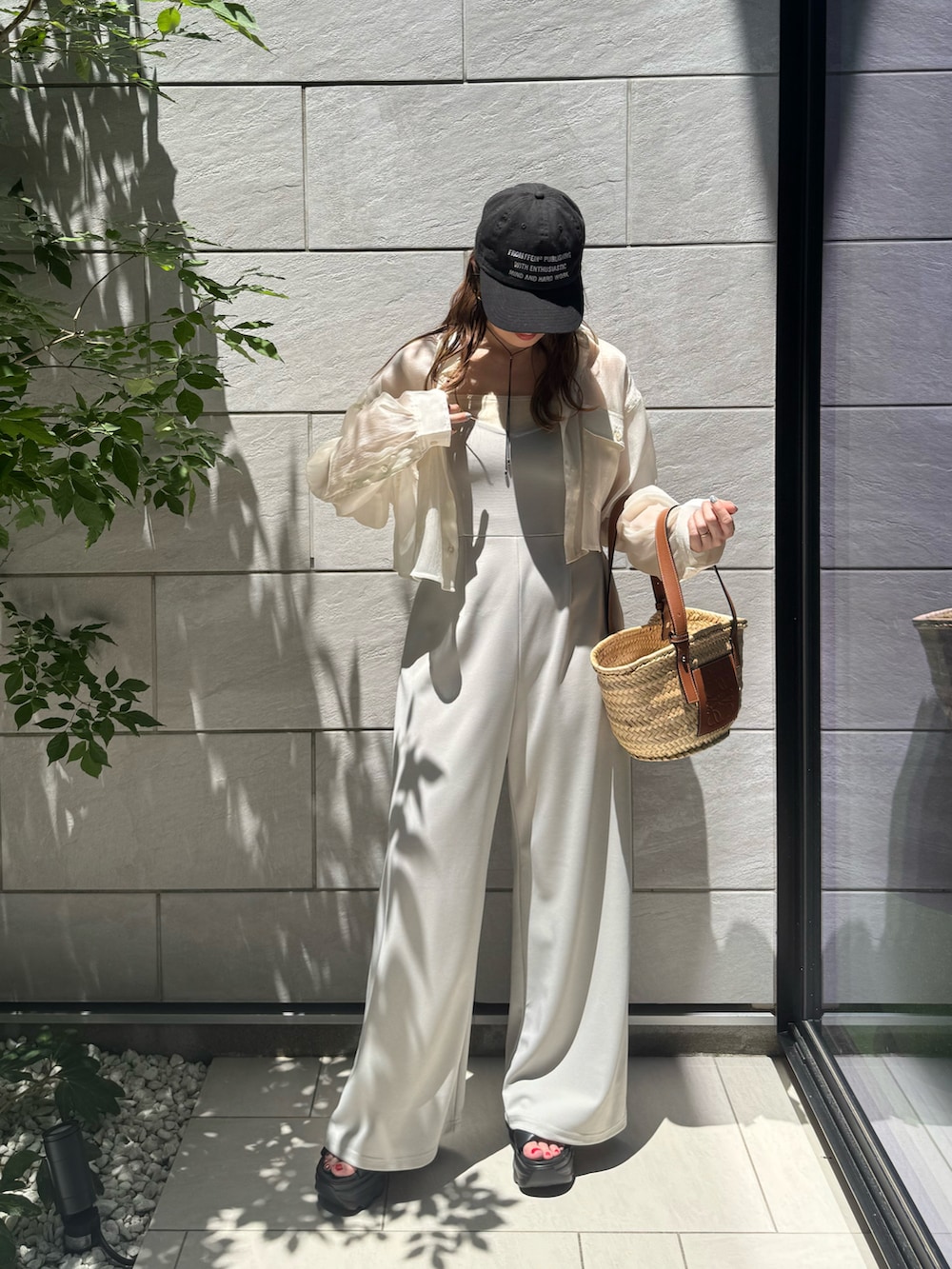 ホワイト系のシャツ/ブラウス、ブラック系のサンダル、ブラウン系のトートバッグを着用したレディースの夏コーディネートの2枚目の写真