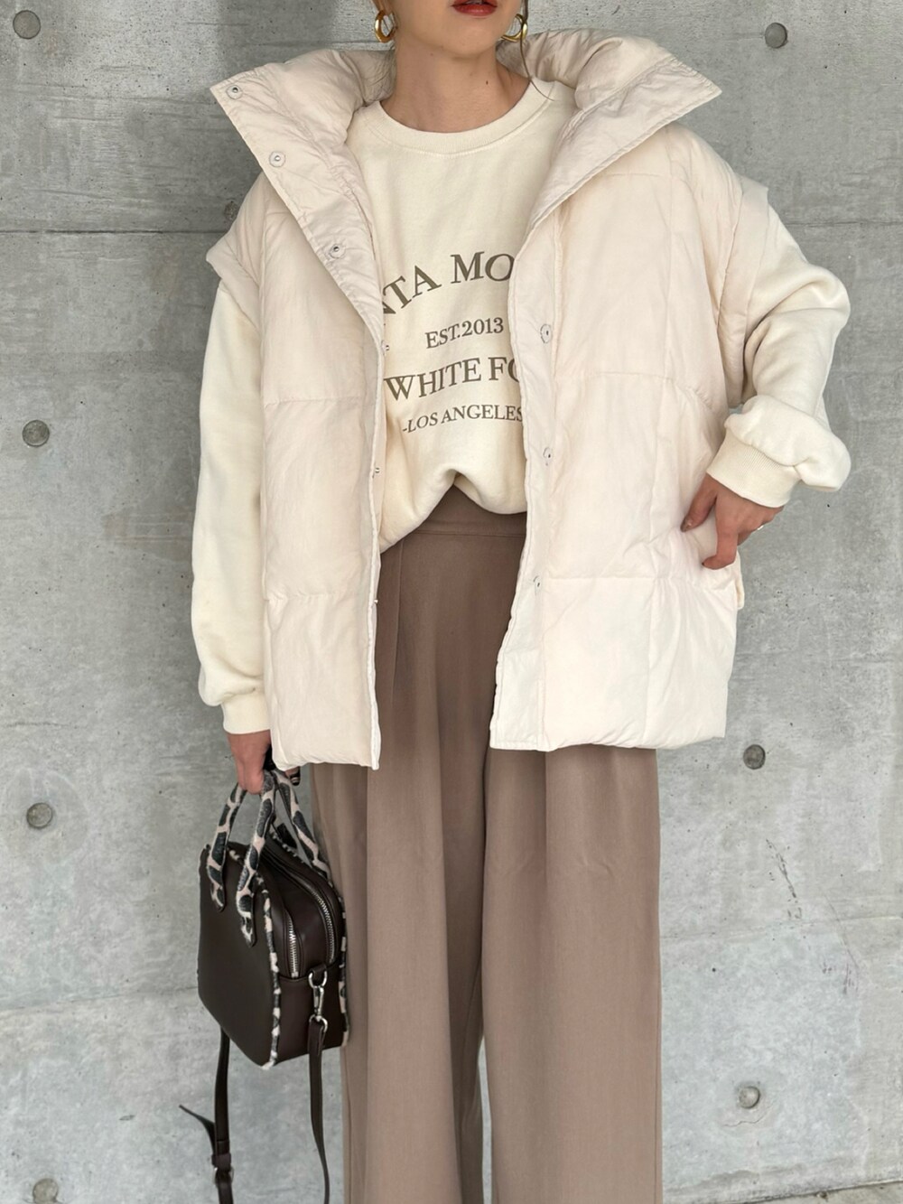 ホワイト系のその他アウター、ブラウン系のその他パンツ、ブラック系のブーツを着用したレディースの秋コーディネートの3枚目の写真