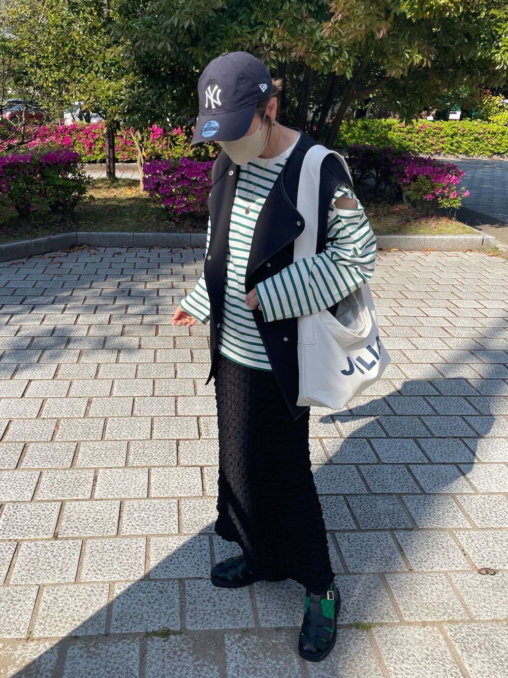 ブラック系のその他シューズ、ブラック系のスカート、ブラック系のベストを着用したレディースの春コーディネートの2枚目の写真