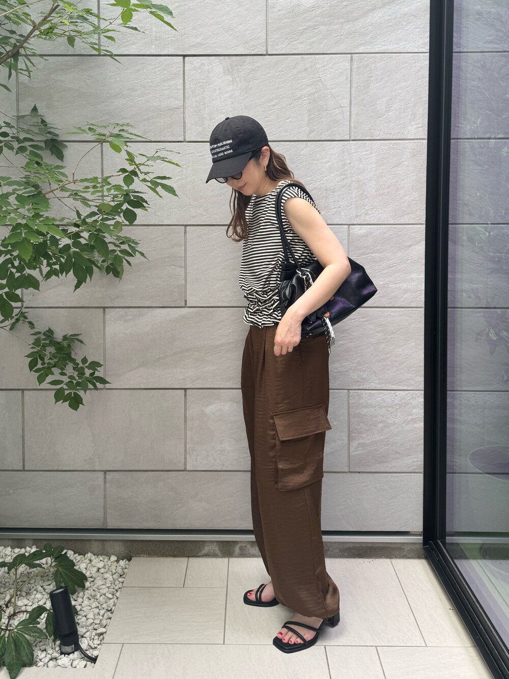 ブラウン系のその他パンツ、ブラック系のTシャツ/カットソー、ブラック系のボストンバッグを着用したレディースの夏コーディネートの4枚目の写真