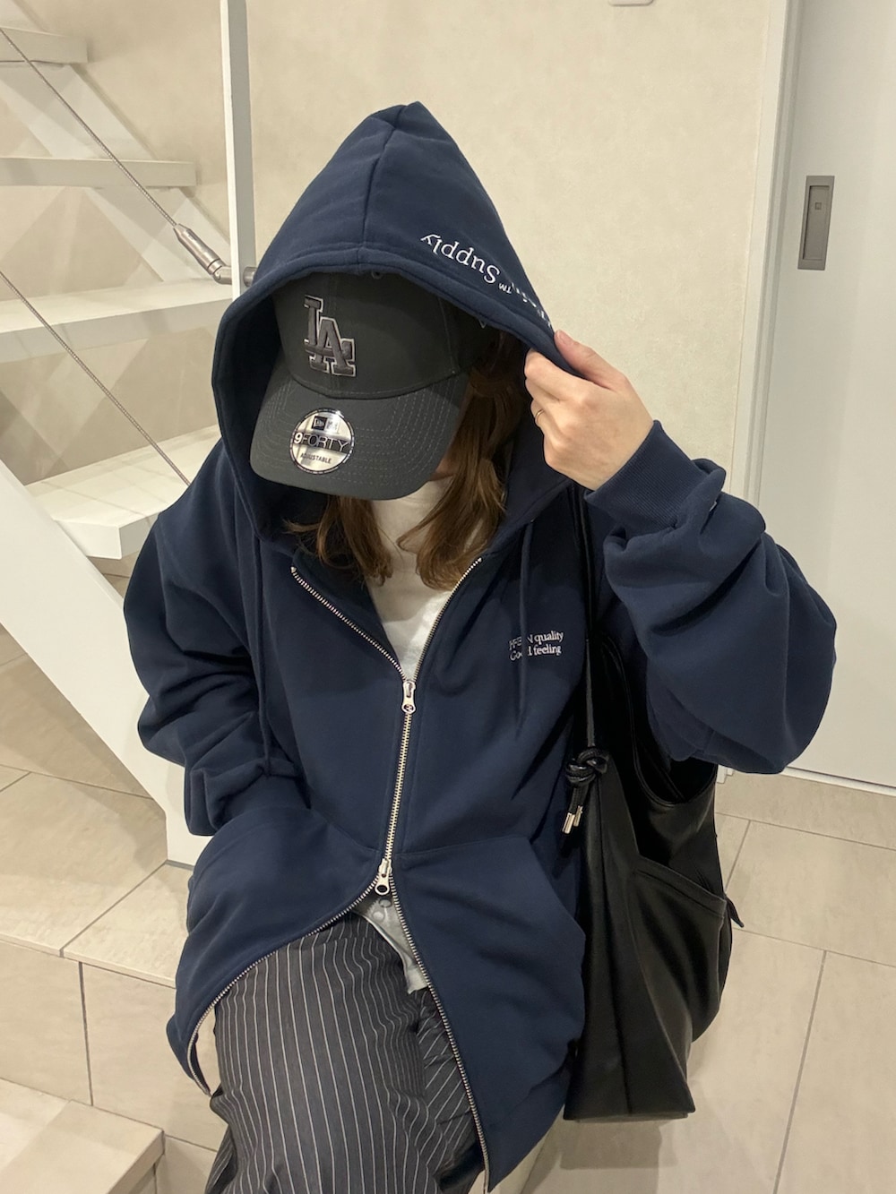 ブルー系のパーカー、グレー系のスラックス、イエロー系のスニーカーを着用したレディースの冬コーディネートの4枚目の写真