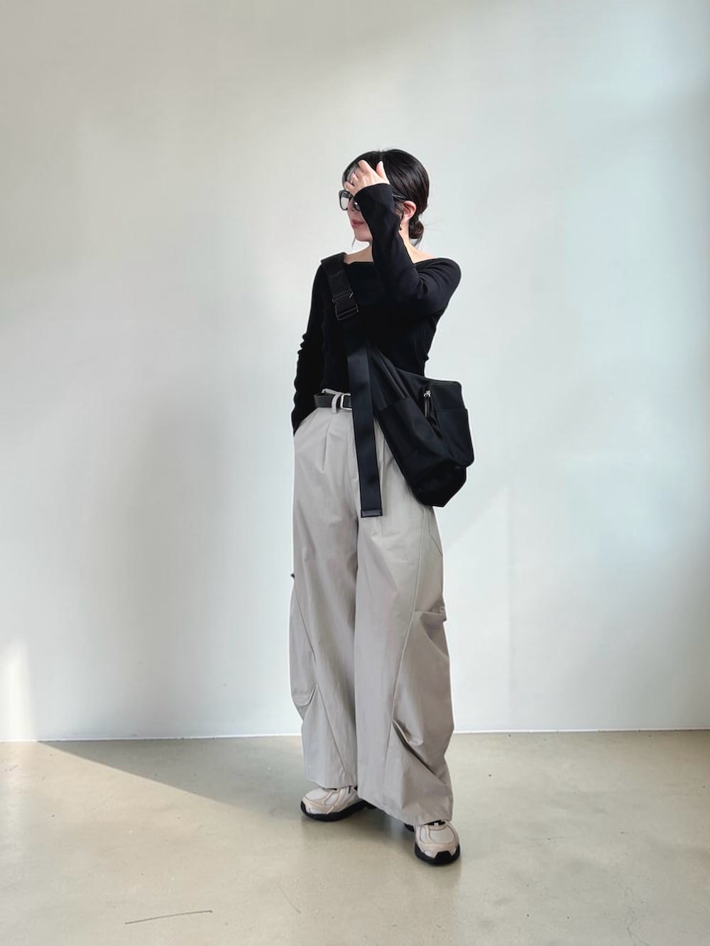 ブラック系のTシャツ/カットソー、グレー系のその他パンツ、ブラック系のショルダーバッグを着用したレディースの春コーディネートの2枚目の写真