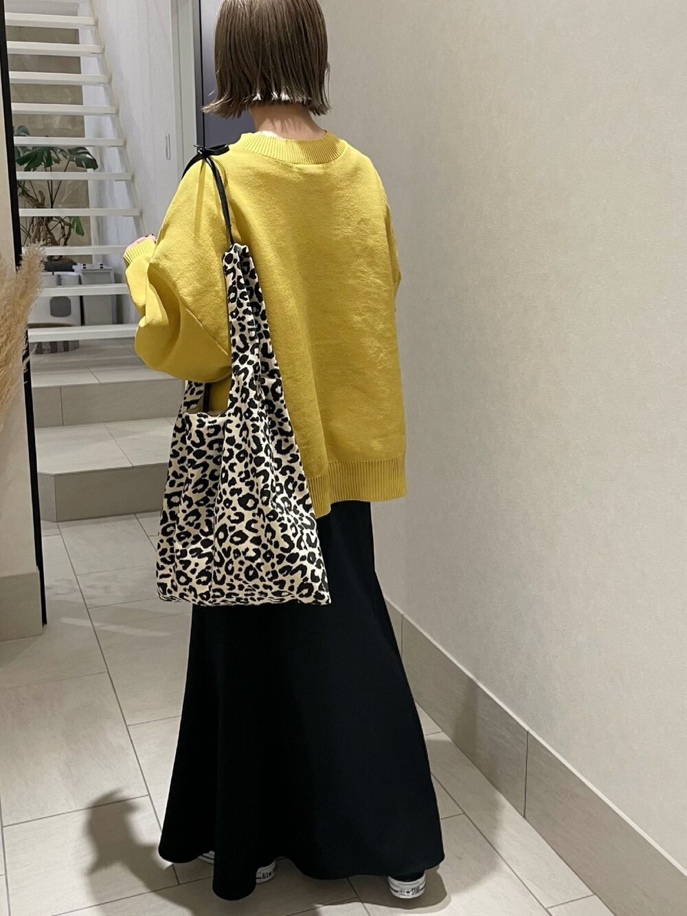 イエロー系のニット/セーター、その他のトートバッグ、ブラック系のスカートを着用したレディースの冬コーディネートの5枚目の写真