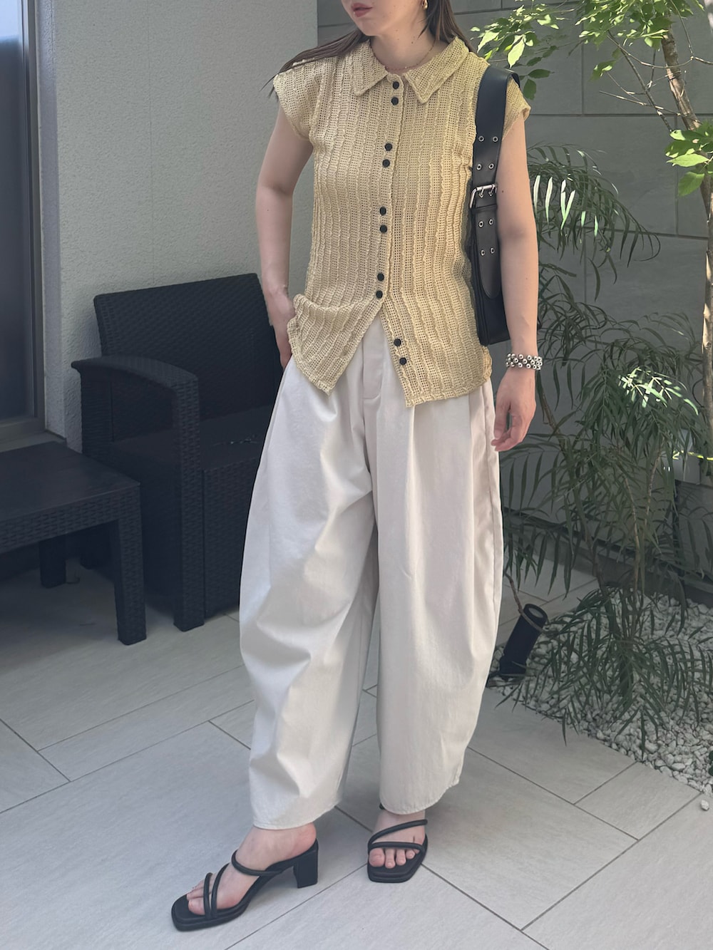 ベージュ系のカーディガン/ボレロ、ホワイト系のチノパンツ、ブラック系のサンダルを着用したレディースの夏コーディネートの3枚目の写真