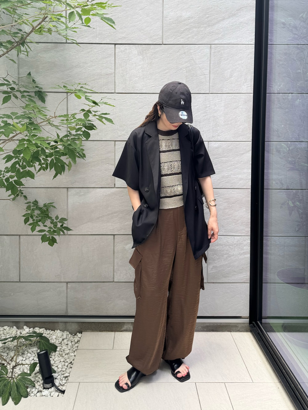グリーン系のタンクトップ、ブラウン系のその他パンツ、ブラック系のボストンバッグを着用したレディースの夏コーディネートの4枚目の写真