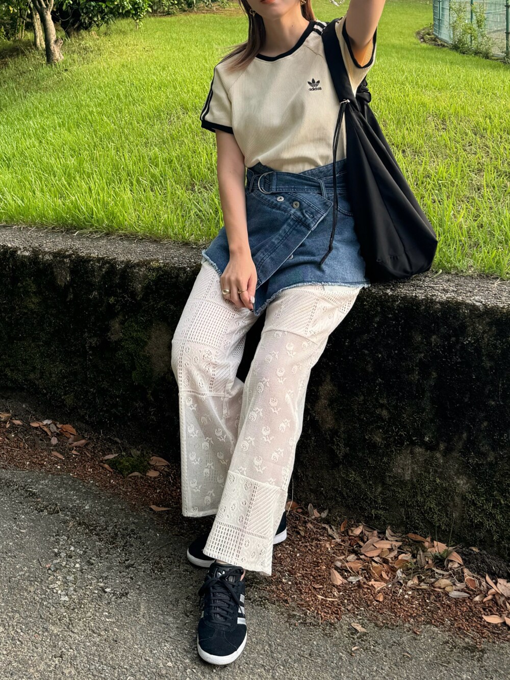 ホワイト系のTシャツ/カットソー、ブラック系のスニーカー、ブラック系のショルダーバッグを着用したレディースの夏コーディネートの2枚目の写真