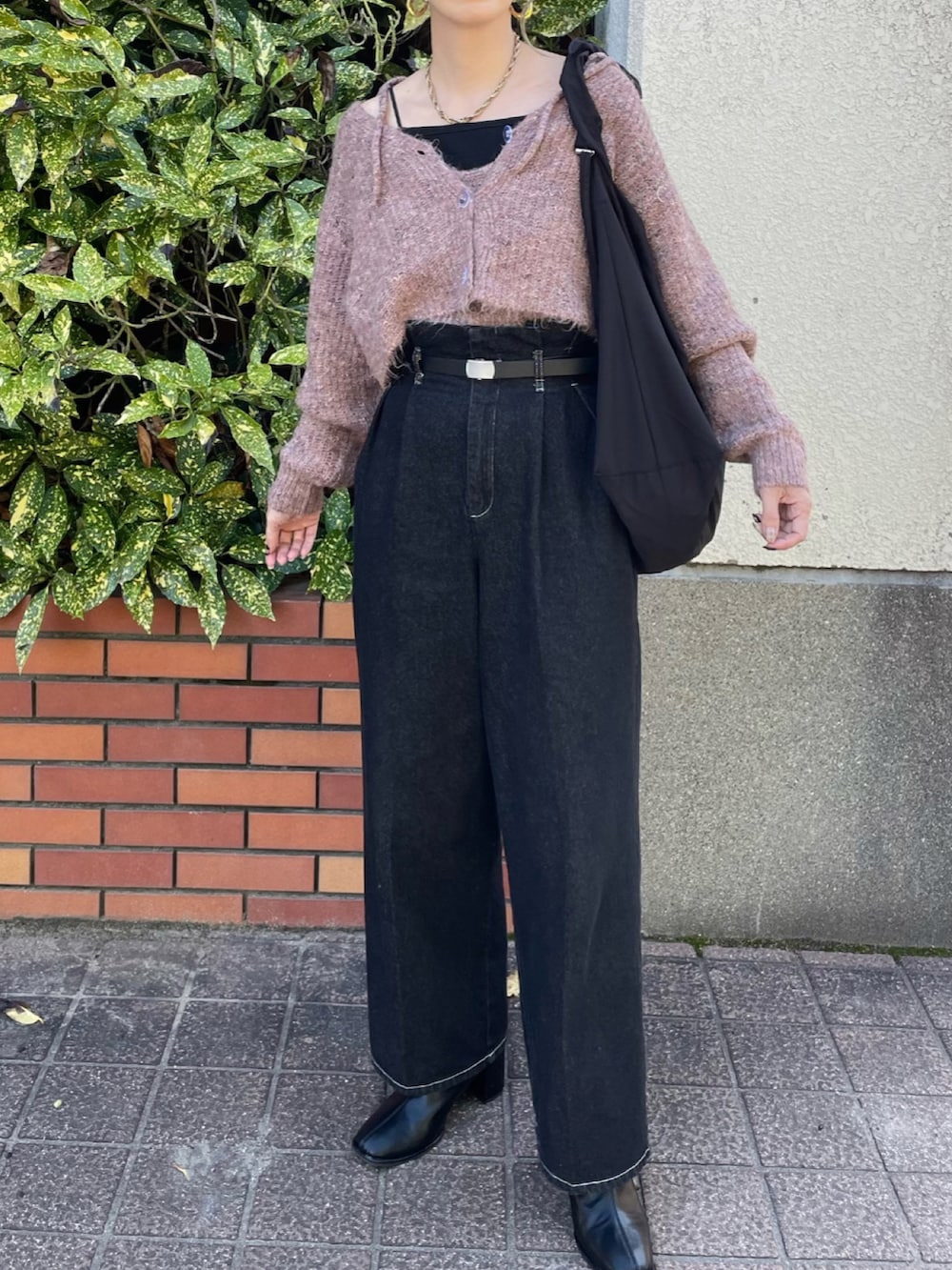 ピンク系のカーディガン/ボレロ、ブラック系のショルダーバッグ、ブラック系のデニムパンツを着用したレディースの秋コーディネートの4枚目の写真
