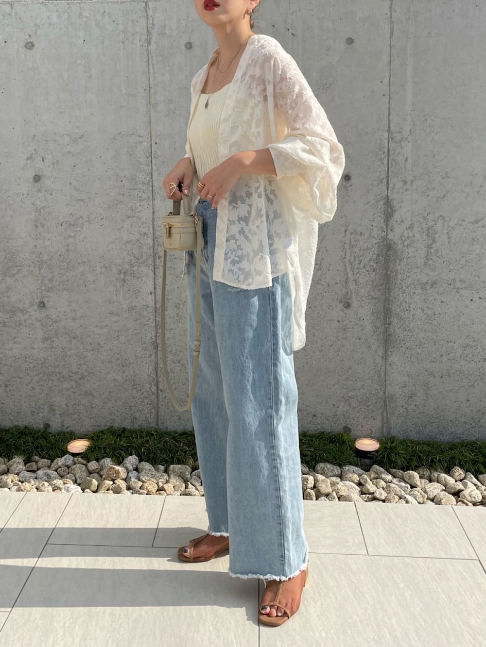 ホワイト系のシャツ/ブラウス、ブルー系のデニムパンツ、ベージュ系のショルダーバッグを着用したレディースの夏コーディネートの3枚目の写真