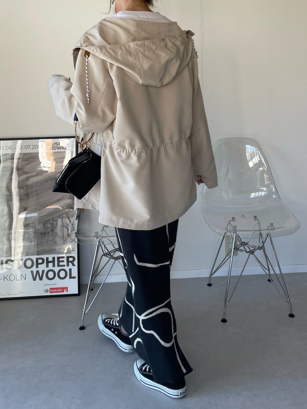 ホワイト系のマウンテンパーカー、グレー系のスカート、ブラック系のハンドバッグを着用したレディースの春コーディネートの4枚目の写真