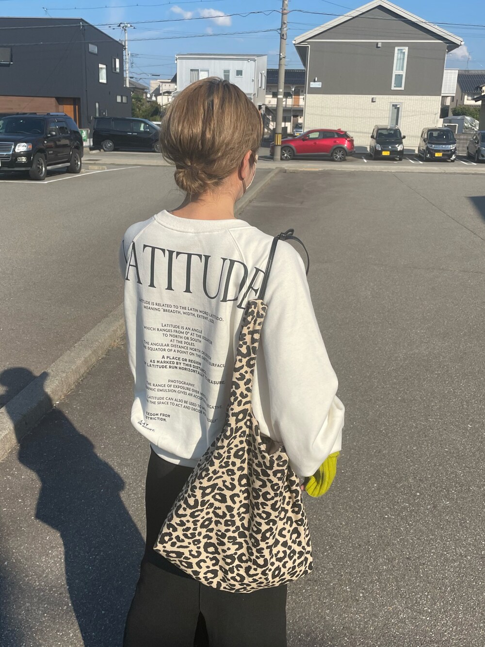 ホワイト系のスウェット、ブラック系のブーツ、ブラック系のスカートを着用したレディースの秋コーディネートの2枚目の写真