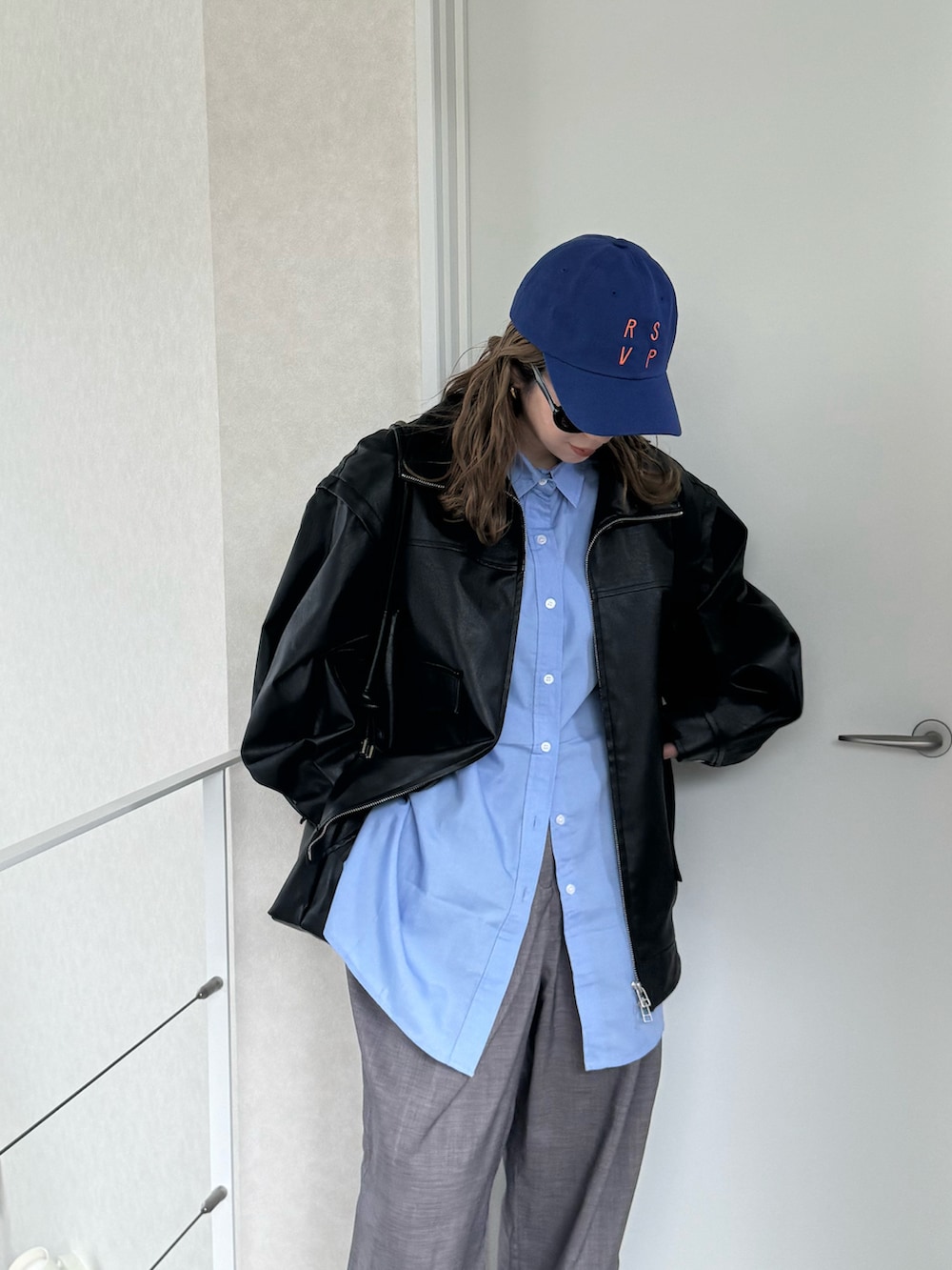 ブルー系のシャツ/ブラウス、グレー系のスラックス、ブラック系のライダースジャケットを着用したレディースの冬コーディネートの3枚目の写真