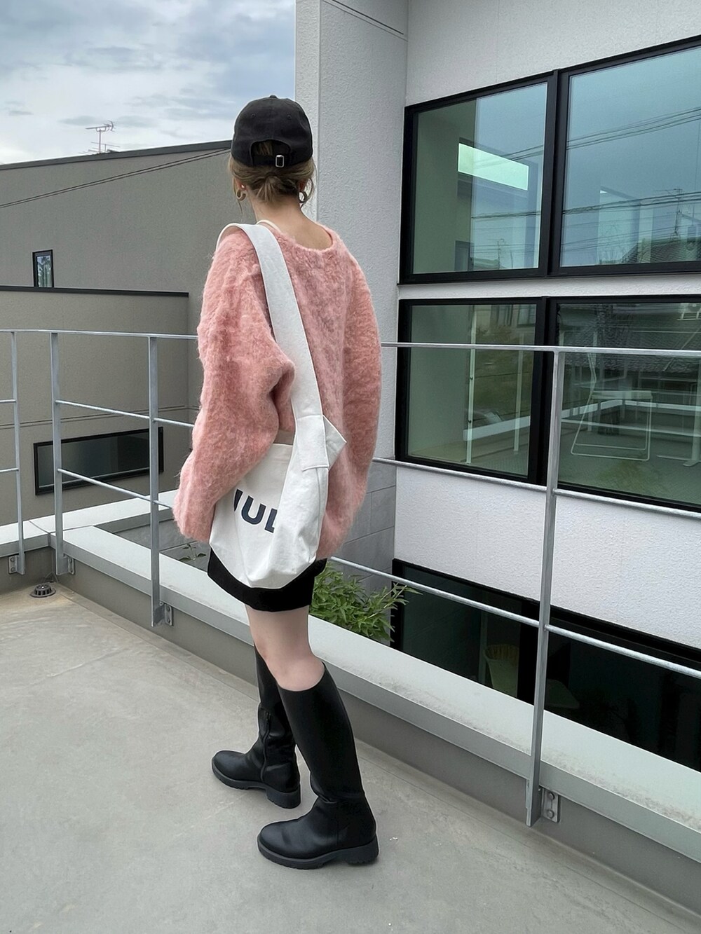 オレンジ系のニット/セーター、ブラック系のその他パンツ、ホワイト系のキャミソールを着用したレディースの秋コーディネートの3枚目の写真
