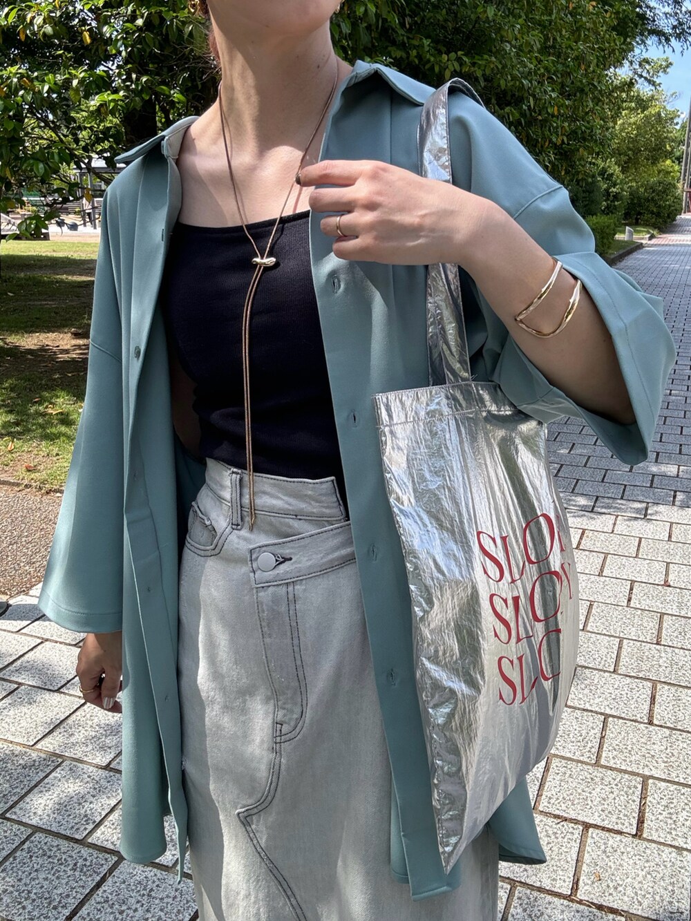 ブラック系のキャミソール、ブルー系のシャツ/ブラウス、ブラック系のサンダルを着用したレディースの春コーディネートの5枚目の写真