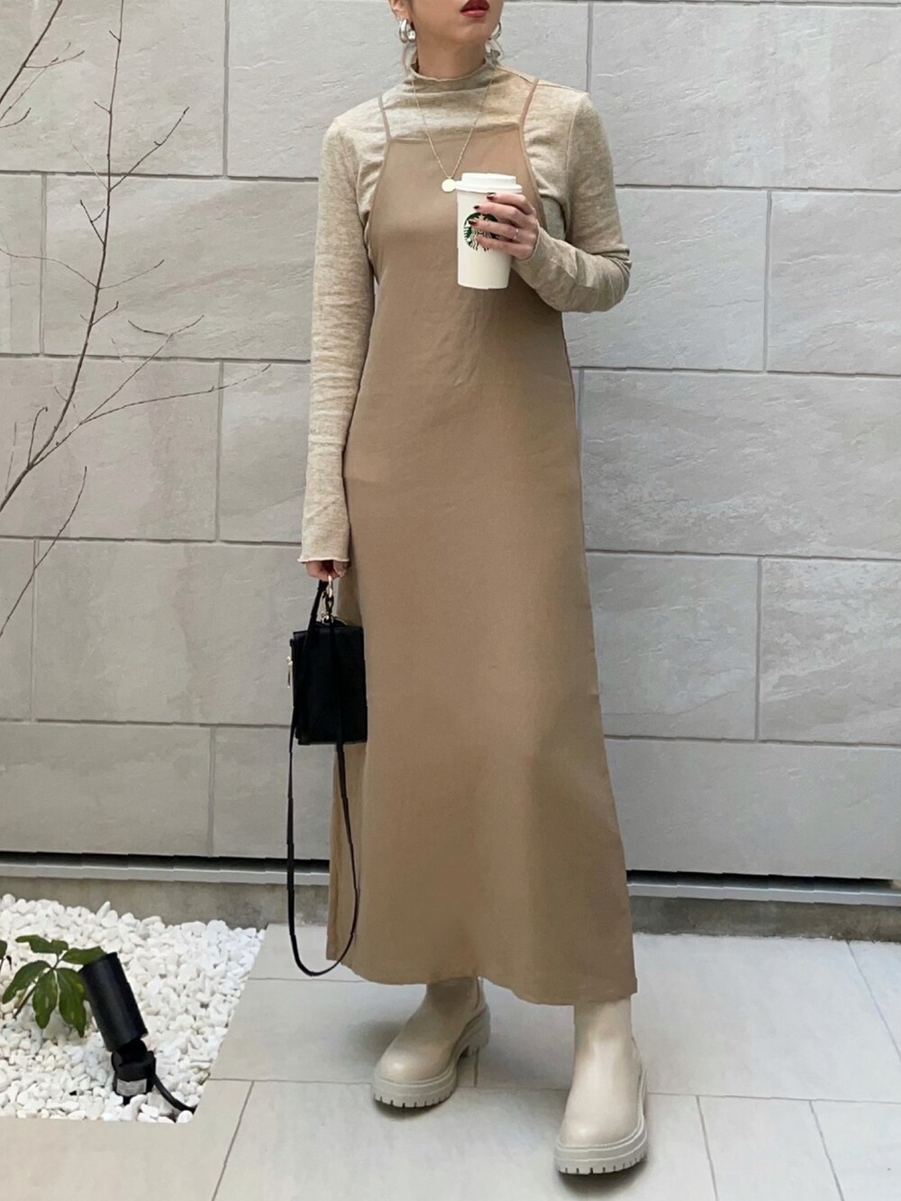 ベージュ系のワンピース、ホワイト系のカーディガン/ボレロ、ホワイト系のブーツを着用したレディースの冬コーディネートの2枚目の写真