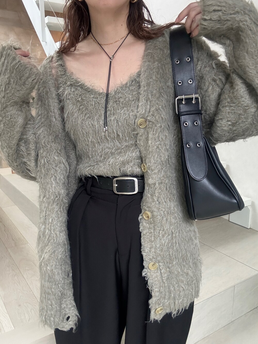 グレー系のカーディガン/ボレロ、ブラック系のスニーカー、ブラック系のハンドバッグを着用したレディースの秋コーディネートの4枚目の写真