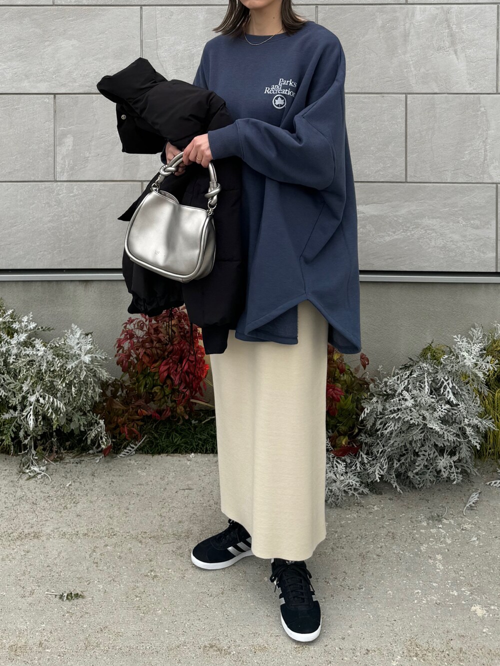 ブルー系のスウェット、シルバー系のショルダーバッグ、ブラック系のスニーカーを着用したレディースの冬コーディネートの3枚目の写真