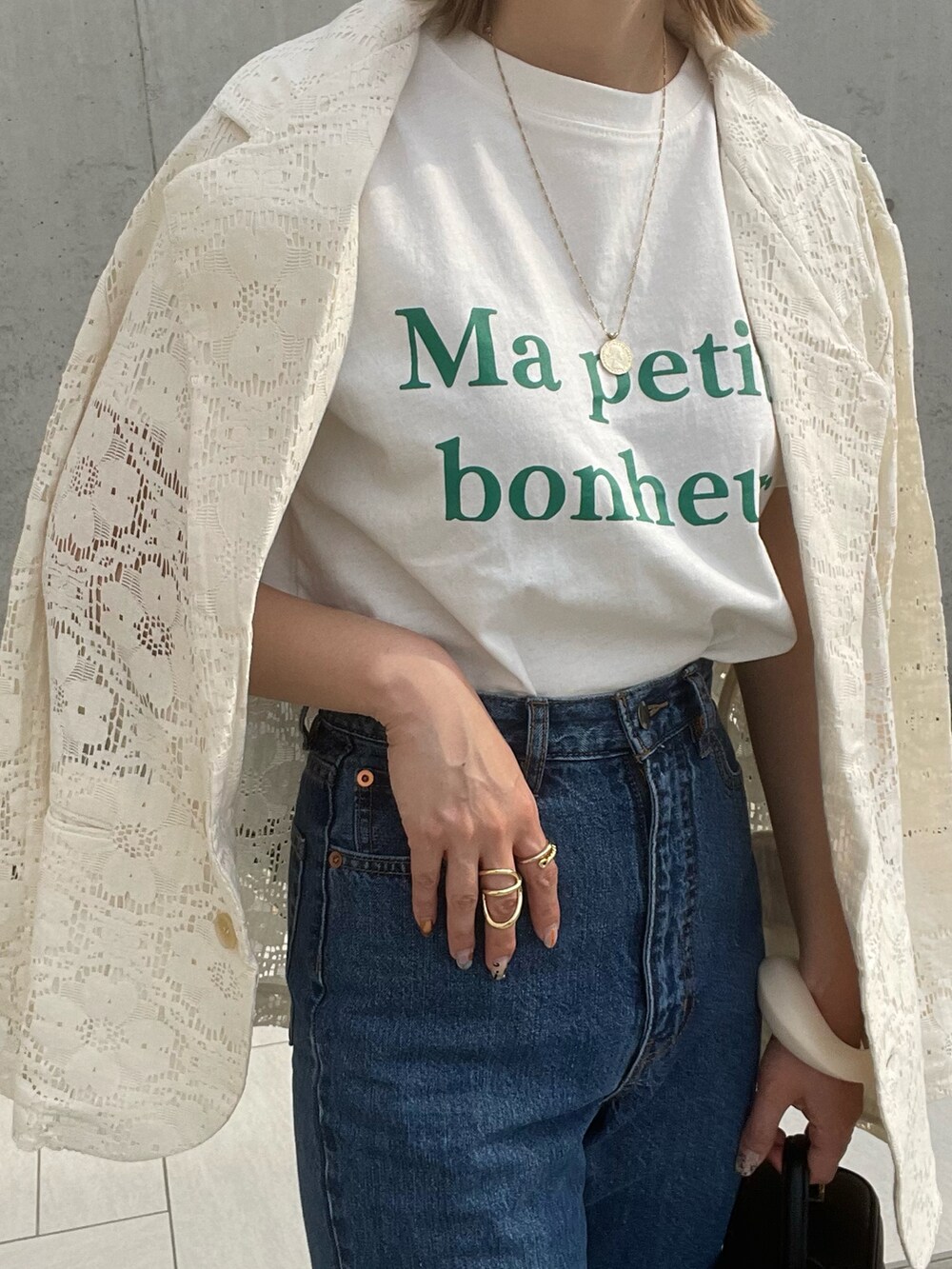 ホワイト系のTシャツ/カットソー、ホワイト系のテーラードジャケット、ブルー系のデニムパンツを着用したレディースの春コーディネートの3枚目の写真