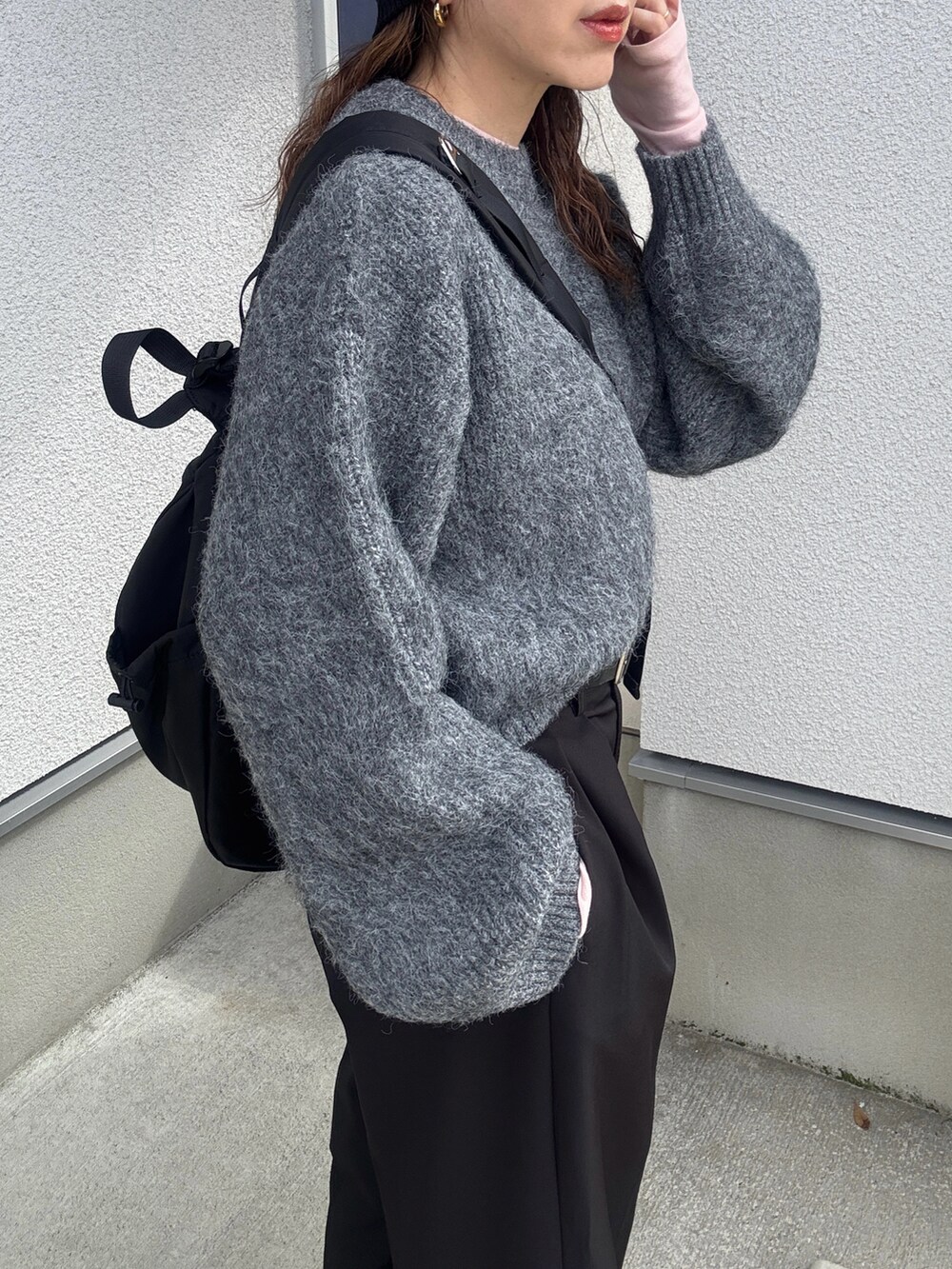 グレー系のニット/セーター、ブラック系のその他パンツ、ブラック系のボディバッグ/ウエストポーチを着用したレディースの秋コーディネートの4枚目の写真