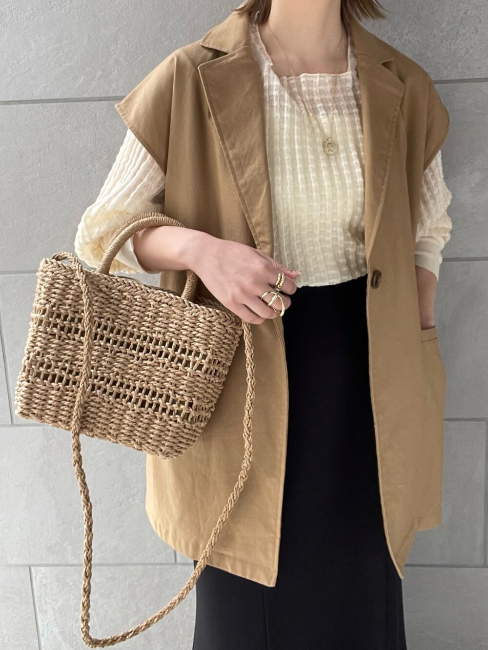 イエロー系のベスト、ホワイト系のニット/セーター、ホワイト系のパンプスを着用したレディースの春コーディネートの5枚目の写真