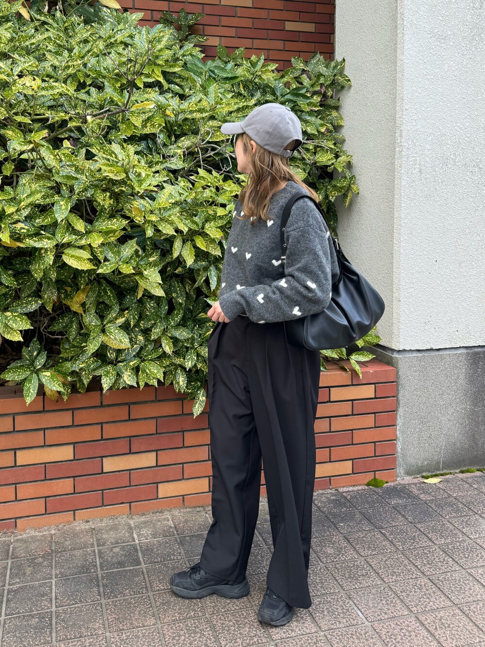 グレー系のニット/セーター、ブラック系のハンドバッグ、ブラック系のその他パンツを着用したレディースの秋コーディネートの5枚目の写真