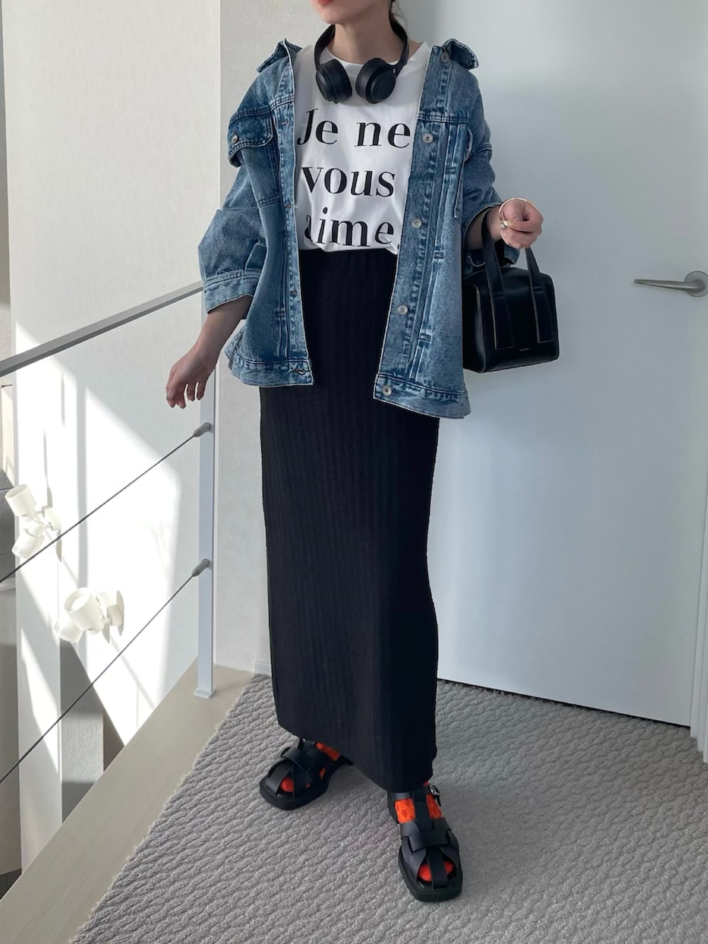 ホワイト系のTシャツ/カットソー、ブラック系のスカート、ブラック系のサンダルを着用したレディースの春コーディネートの3枚目の写真