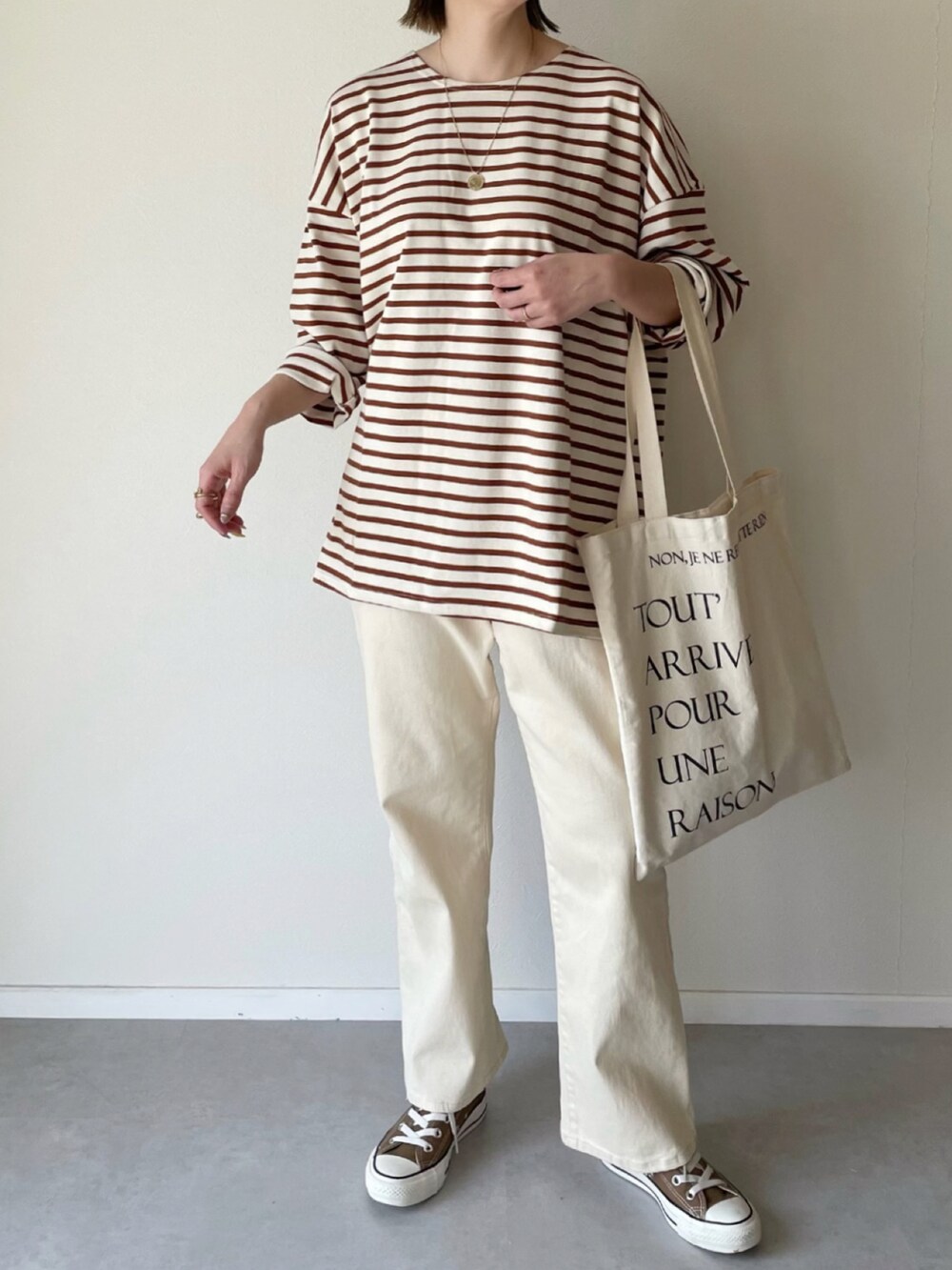 ベージュ系のTシャツ/カットソー、ホワイト系のデニムパンツを着用したレディースの春コーディネートの3枚目の写真