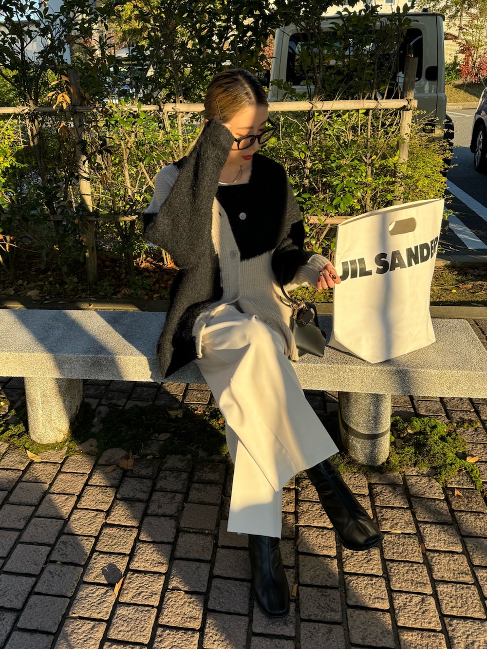 ブラック系のカーディガン/ボレロ、ホワイト系のその他パンツ、ブラック系のハンドバッグを着用したレディースの秋コーディネートの5枚目の写真