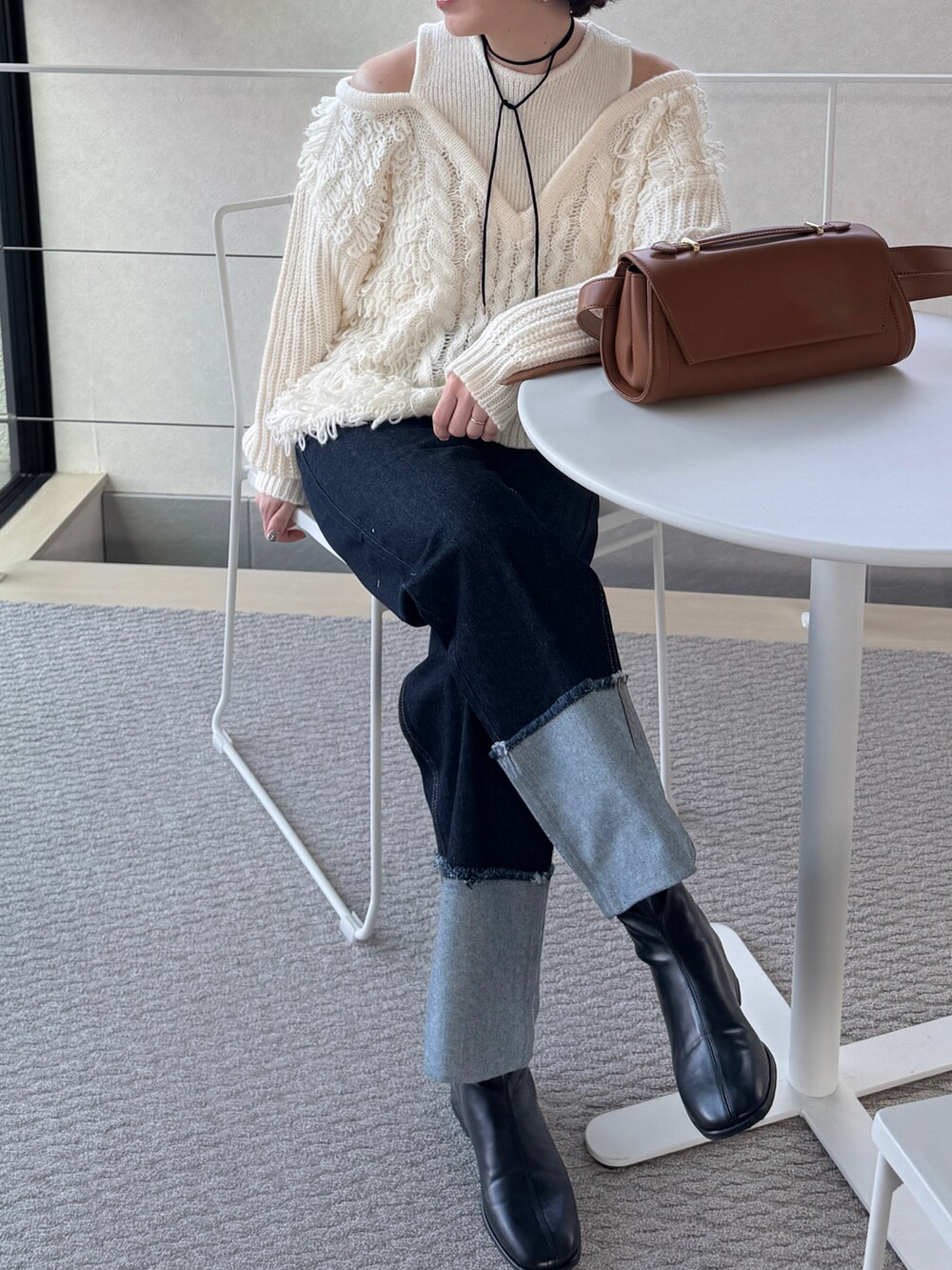 ブルー系のデニムパンツ、ベージュ系のショルダーバッグ、ホワイト系のニット/セーターを着用したレディースの秋コーディネートの5枚目の写真
