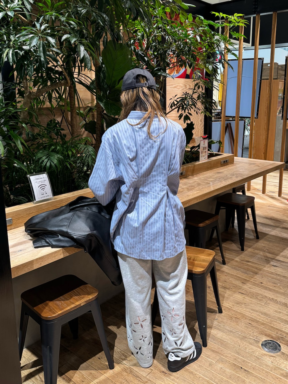 ブルー系のシャツ/ブラウス、グレー系のスウェットパンツ、ブラック系のスニーカーを着用したレディースの春コーディネートの4枚目の写真