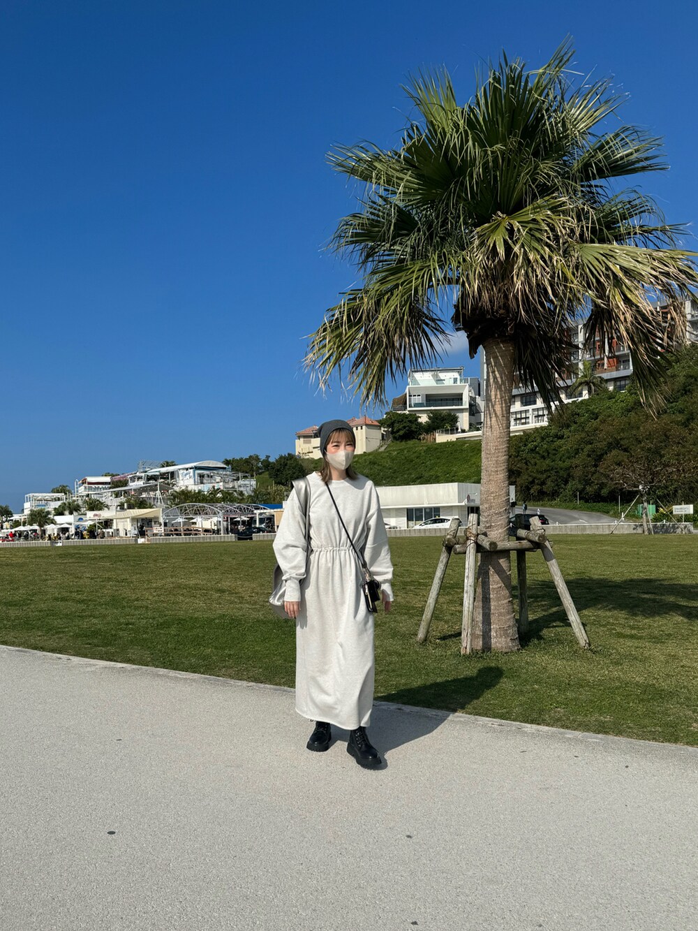 シルバー系のトートバッグ、ブラック系のブーツ、グレー系のニットキャップ/ビーニーを着用したレディースの冬コーディネートの3枚目の写真